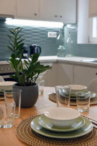 a table with a bowl and plates and glasses on it at Krios Summer Stay in Ermoupoli
