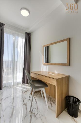 a desk with a mirror and a chair in a room at The St Pauls Bay Escape Suites by 360 Estates in St Paul's Bay