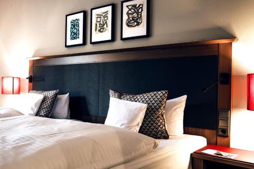 a bedroom with a large bed with a black headboard at AMERON Bonn Hotel Königshof in Bonn