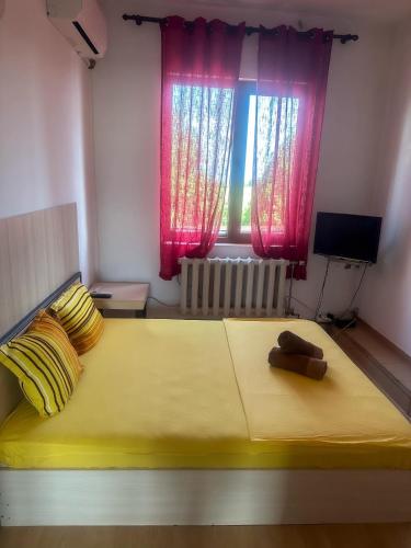 a bedroom with a large yellow bed with a window at ТРАКАРТ-ПАРК in Plovdiv