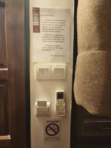 a cell phone and a sign on a wall at Red Inn Court in George Town