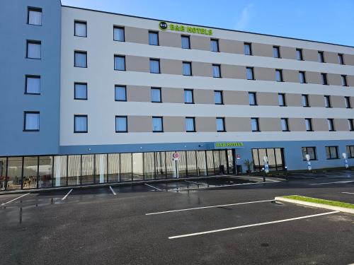 an empty parking lot in front of a building at B&B HOTEL Deauville-Touques in Deauville