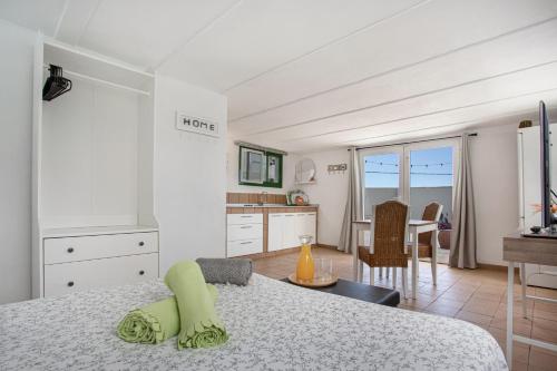 Un dormitorio con una cama y una cocina y una mesa. en Piscina Climatizada, en La Hidalga