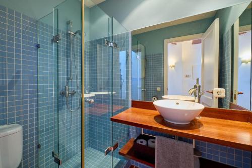 a bathroom with a sink and a glass shower at Sa Calma in Llafranc