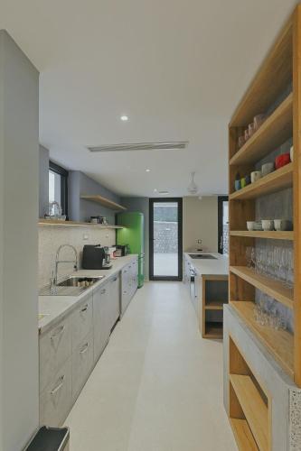 a large kitchen with wooden shelves and a long hallway at Orlovo gnezdo in Ljubovija