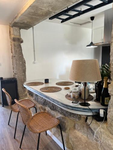 a kitchen with a counter with chairs and a lamp at Mirada Do Roxo in Oia