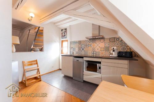 une cuisine avec des appareils en acier inoxydable et un escalier dans l'établissement Au Bonheur des Anges Appartement duplex, à Colmar