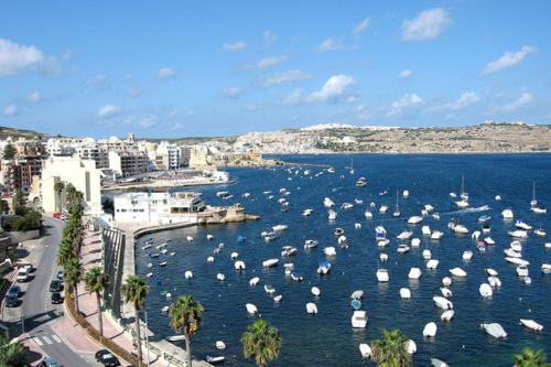 a harbor with many white umbrellas in the water at The St Pauls Bay Escape Suites by 360 Estates in St Paul's Bay