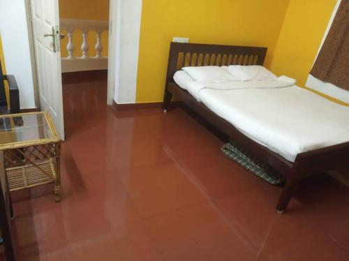 two beds in a room with a red floor at Prince Park in Puducherry