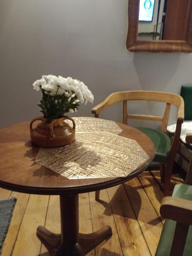 a table with a vase of white flowers on it at Alte Brennerei Apartments in Traben-Trarbach