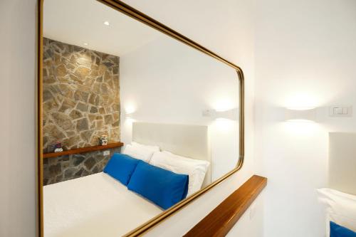 a mirror reflecting a bed with blue pillows at Villa Torù in Castellabate