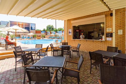 a patio with tables and chairs next to a pool at Sovinyon Resort in Odesa