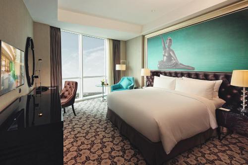 a hotel room with a bed and a large window at Hotel Ciputra World Surabaya managed by Swiss-Belhotel International in Surabaya