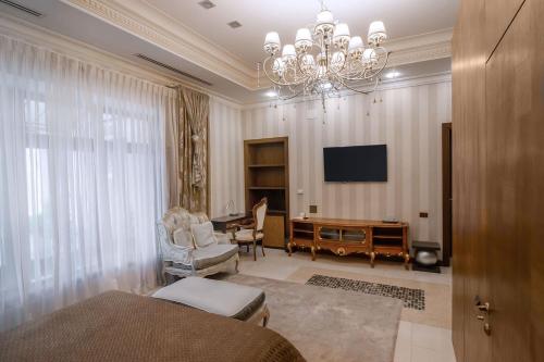 a large living room with a chandelier and a television at Shato Luxe in Odesa