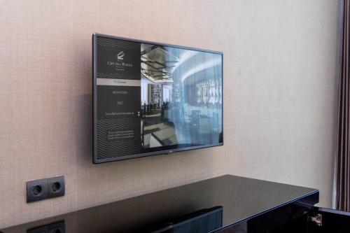 a flat screen tv hanging on a wall at Hotel Ciputra World Surabaya managed by Swiss-Belhotel International in Surabaya