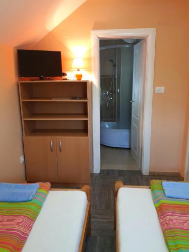 a room with two beds and a bathroom with a tub at Vila Vitezov Mir - Drina in Vrhpolje