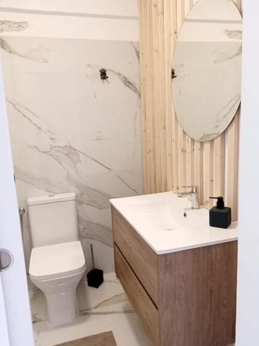 a bathroom with a toilet and a sink and a mirror at A Minha Casinha in Almada
