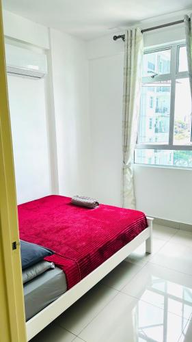 a bedroom with a red bed with a window at Spice Arena Service Apartment in Bayan Lepas