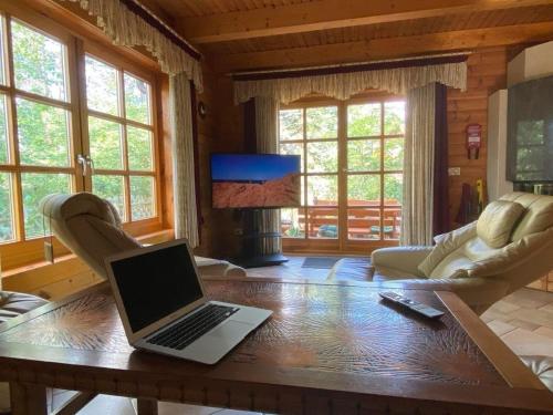 a laptop sitting on a wooden table in a living room at Schönes Ferienhaus in Schmiedeberger Weinberge mit Terrasse und Grill in Bad Schmiedeberg