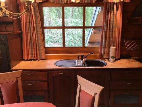 a kitchen counter with a sink and a window at Schönes Ferienhaus in Schmiedeberger Weinberge mit Terrasse und Grill in Bad Schmiedeberg
