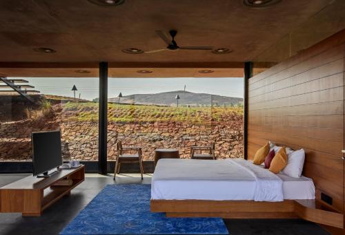 a bedroom with a bed and a large window at Beyond by Sula in Nashik