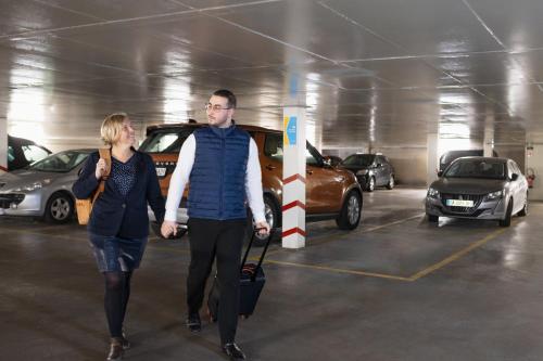 a man and woman walking through a parking garage at Mercure Nancy Centre Place Stanislas in Nancy
