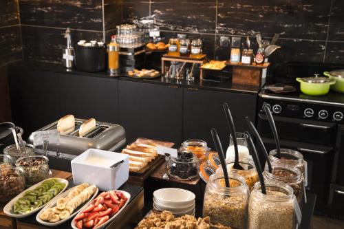 a buffet of food on a table in a kitchen at Mercure Nancy Centre Place Stanislas in Nancy