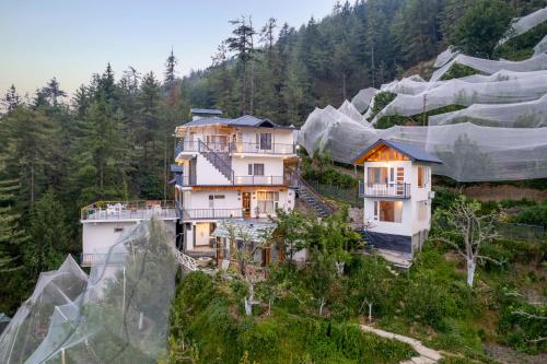an aerial view of a house on a mountain at Jomotel Dayaar - An Apple Orchard Villa in Theog