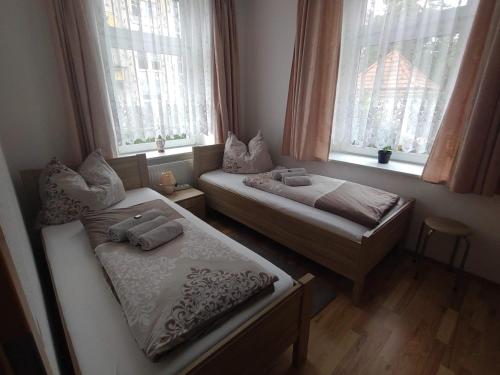 two beds in a room with two windows at Ferienwohnung Lange in Burgstaedt