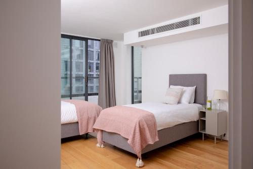 ロンドンにあるBob W Tower Hill Residencesのベッド2台と窓のある寝室