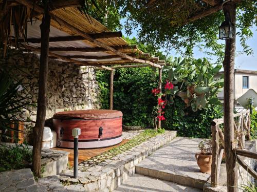 a wooden pergola with a barrel in a garden at Villa Rafael - A Romantic Gem in Amalfi Coast in Maiori