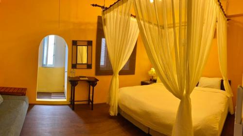 a bedroom with a bed with curtains and a window at Bellalia 貝拉利亞 花蓮民宿 in Hualien City