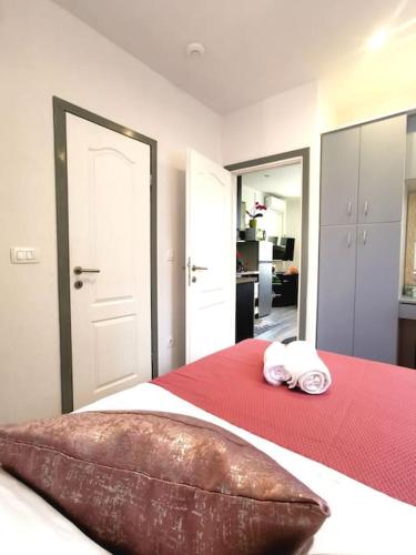 a bedroom with a bed with a red blanket and two towels at Apartment Beba in Kaštela
