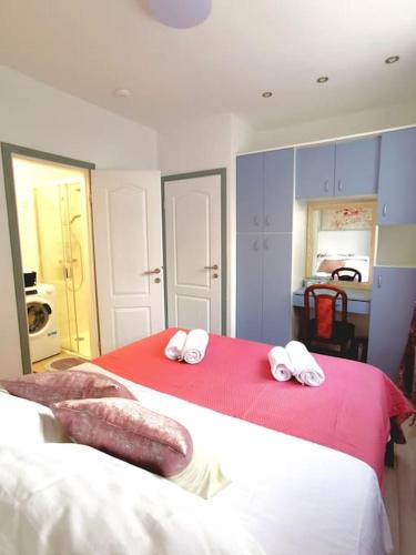 a bedroom with two beds with red and white sheets at Apartment Beba in Kaštela
