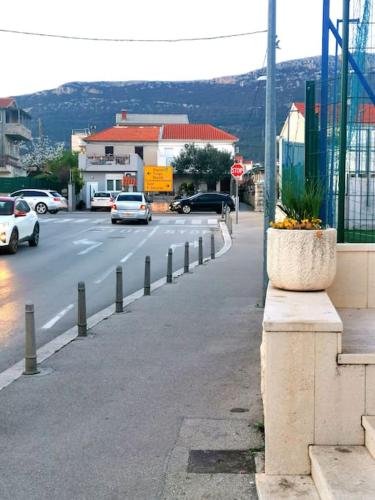 a street with cars driving down the road at Apartment Beba in Kaštela