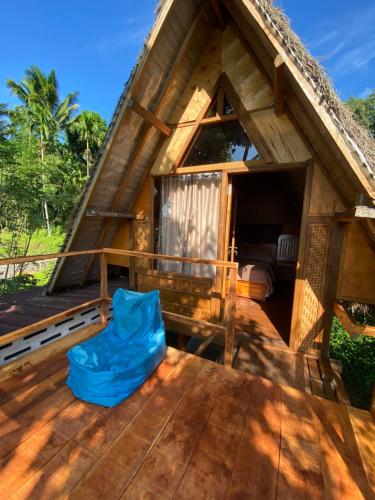 a blue chair sitting on the deck of a house at The Alam Bungalow & Restaurant in Tetebatu