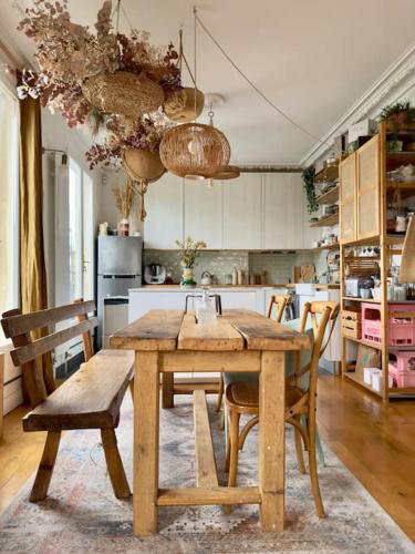 - une cuisine avec une table à manger en bois et des chaises dans l'établissement Magnifique Appartement 6P - Paris 17eme, à Paris