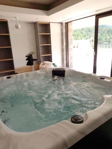 a large bath tub in a room with a large window at Orlovo gnezdo in Ljubovija