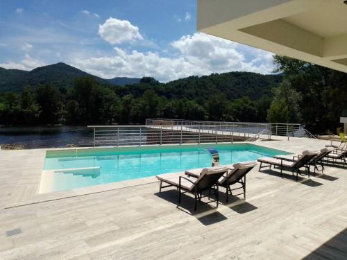 a swimming pool with chairs and a view of the mountains at Orlovo gnezdo in Ljubovija