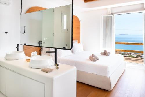 a white bathroom with a white bed and a mirror at The Lion 3 Villa with Sunset Views in Fanari