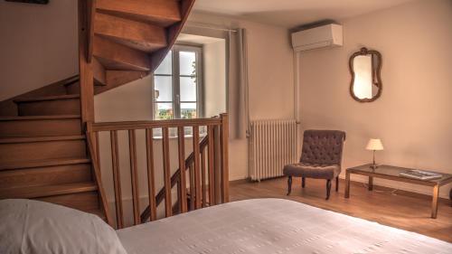 a bedroom with a staircase and a chair and a bed at Maison Melrose in Vouvray