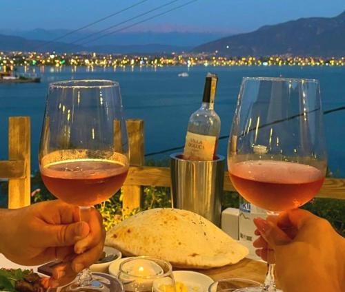 two people holding glasses of wine sitting at a table at Ece Hotel Sovalye Island in Fethiye
