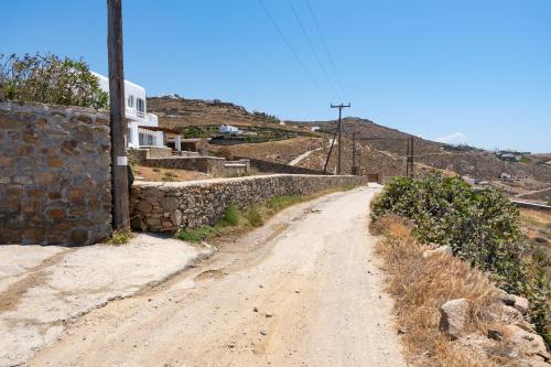 a dirt road next to a stone wall at The Lion 3 Villa with Sunset Views in Fanari