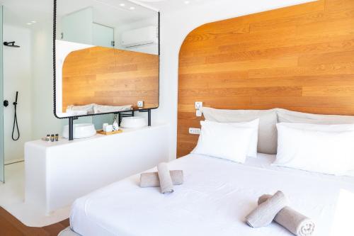 a bedroom with a white bed with a wooden headboard at The Lion 3 Villa with Sunset Views in Fanari