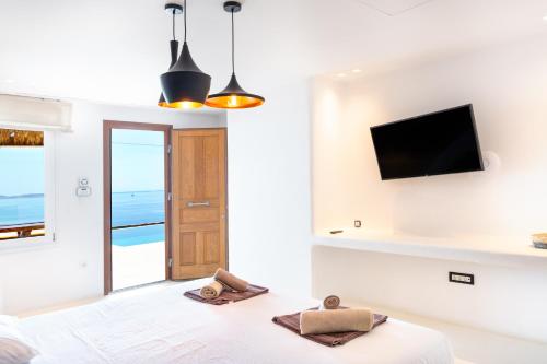 a white bedroom with a view of the ocean at The Lion 3 Villa with Sunset Views in Fanari