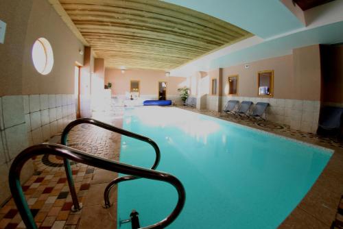 - une piscine avec une barre de maintien dans un bâtiment dans l'établissement Chalet des Neiges Oz en Oisans, à Oz