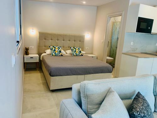 sypialnia z łóżkiem i niebieską kanapą w obiekcie Thelfi Luxury studio in Attica - close to varkiza beach - Sea view w mieście Vari