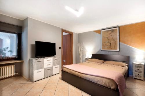 a bedroom with a bed and a flat screen tv at Maison Bebe Terre Blanche in Aosta