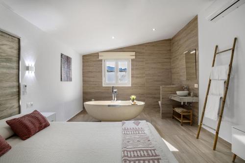 a bathroom with a bed and a tub and a sink at Casa El Buda in Vejer de la Frontera