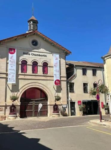 a building on a street with a building with a clock tower at Le Richebourg in Gevrey-Chambertin